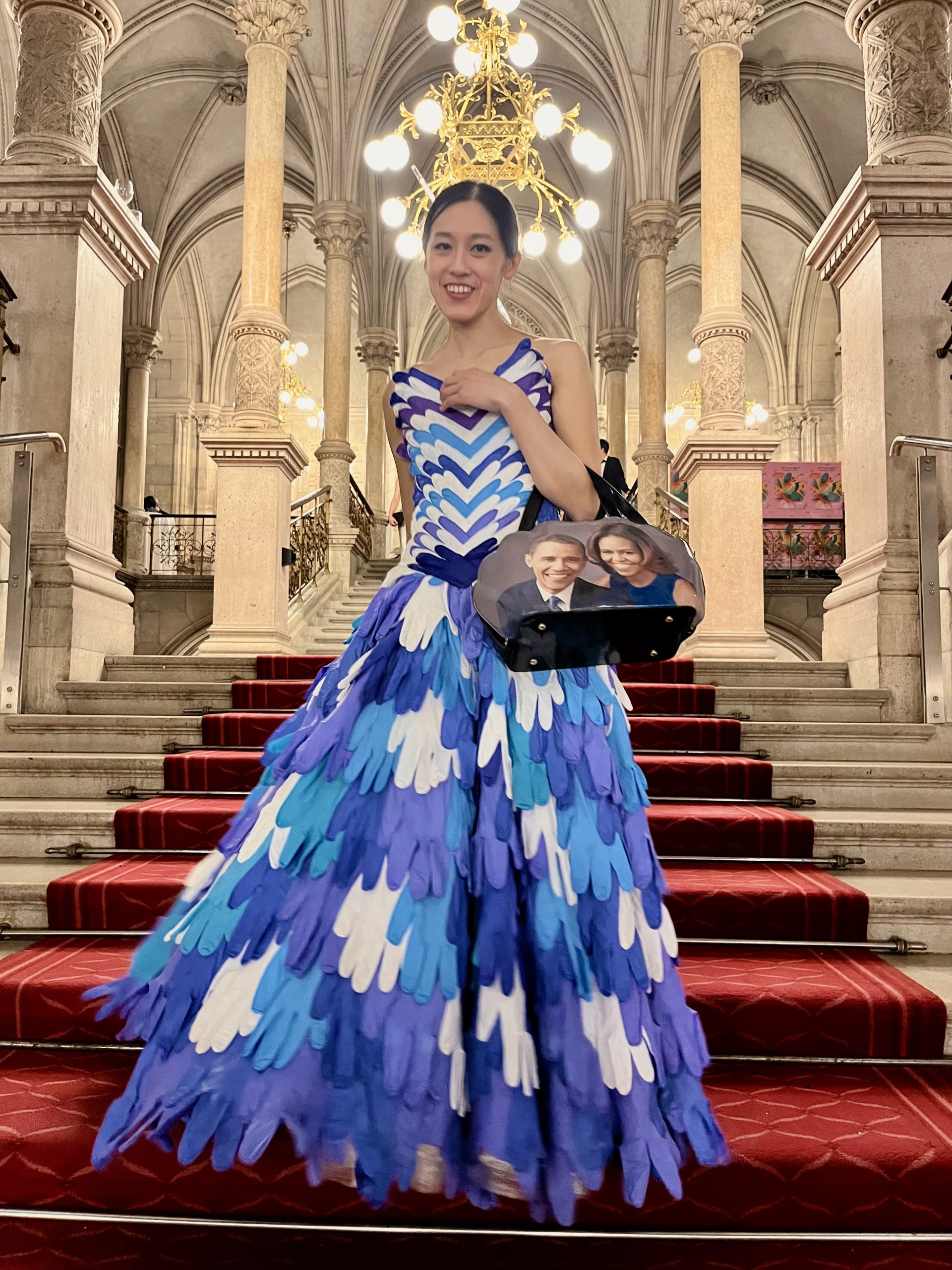 Saki the Artist in a self-sewn dress, primarily made of single-use gloves stitched together. ©SusiToma